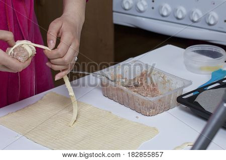 Preparation Of Meat Glomeruli. Stuffed Turkey, Wrapped In Strips Of Puff Pastry. A Woman Winds A Str