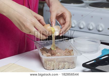 Stages Of Preparation Of Meat Glomeruli. The Woman Adds A Chicken Egg To The Stuffing. Next To The T