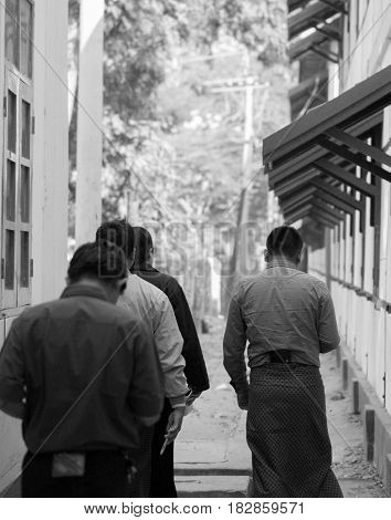 BLACK AND WHITE PHOTO OF WALKING GROUP OF PEOPLE SHOT FROM BACK