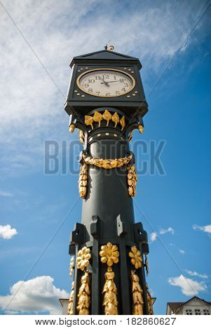 An old golden clock Tower in front of a church