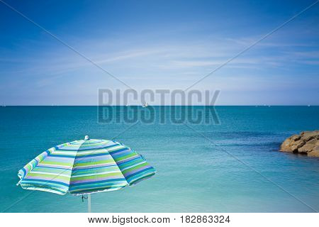 Isolated blue beach umbrella against the sea (Tuscany - Italy)