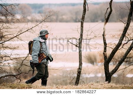 Rogachev, Belarus - February 25, 2017: Re-enactor Dressed As German Wehrmacht Infantry Soldier In WW II Walking In Autumn Forest.