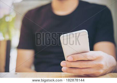 A man holding and using smart phone in modern cafe