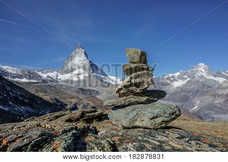 Compare concept of balance stable and equal rocks on the alp with matterhorn in background Switzerland