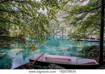 View of red boat in green clear clean water lake in Switzerland