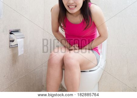 woman feel pain with constipation in the bathroom