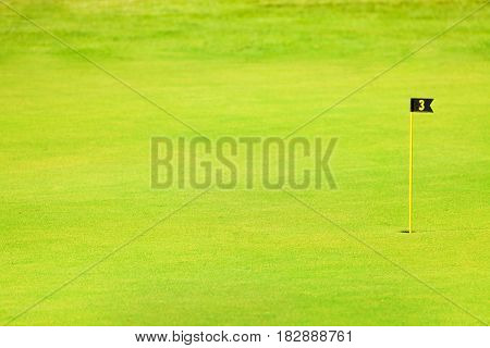 Green fairway of golf course with pin or flagstick and cup