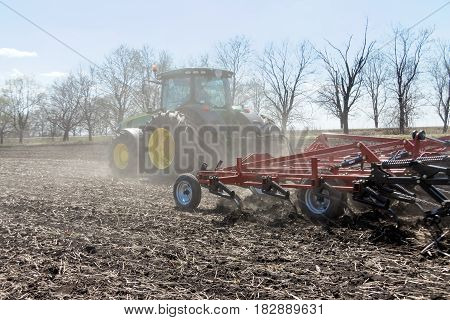 Kharkiv Ukraine - April 13 2017: Tractor with trailed planter working in field in a sunny spring day in Kharkiv Oblast Ukraine on April 13 2017