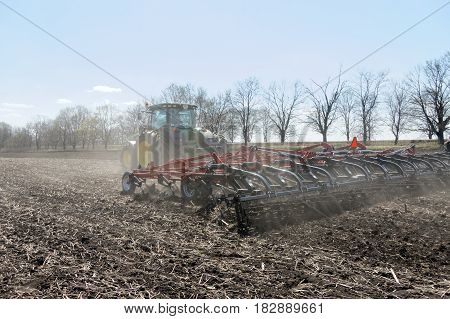 Kharkiv Ukraine - April 13 2017: Tractor with trailed planter working in field in a sunny spring day in Kharkiv Oblast Ukraine on April 13 2017