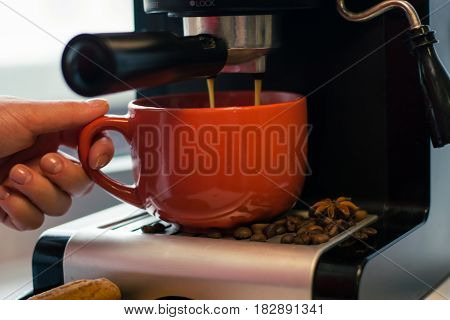 Girl make fresh coffee in a coffee machine with flavoring