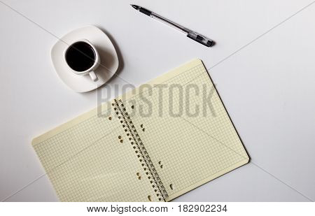 There is a note-book and a pen on the table