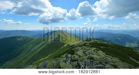 Panoramic view of the mountain ridge in Carpathians Ukraine. Big stones with green moss on the foreground.