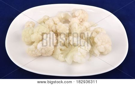 Seasonal salad of pickled cauliflower on blue background