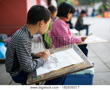Chengdu - Pixian Sichuan Province China - Apr 12 2015: Children learning to draw in a temple