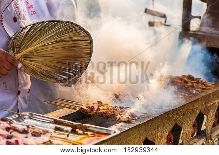 Chengdu Sichuan Province China - Dec 16 2015: Man cooking skewers on a traditional market