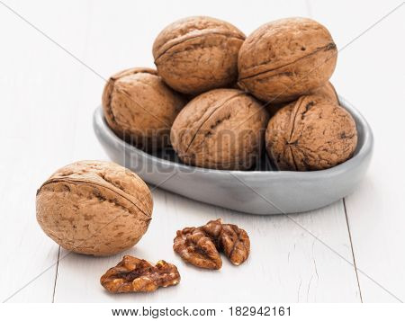 Close up view on inshell walnut on white wooden background