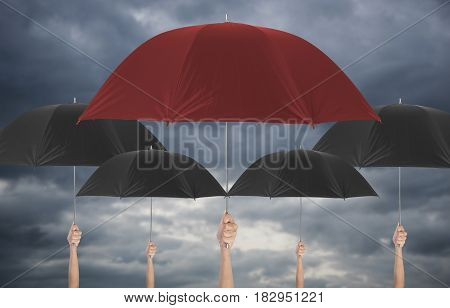 Hand holding red umbrella different among black umbella. insurance policy Life health protection a family conceptaul.