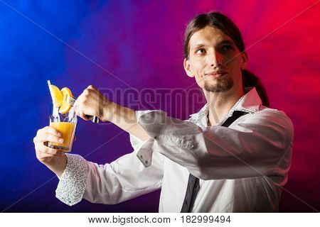 Alcohol liquor party drinking concept. Barman mixing beverages in glass. Male tapster holding drink glass.