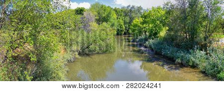Views Of Jordan River Trail With Surrounding Trees, Russian Olive, Cottonwood And Silt Filled Muddy 