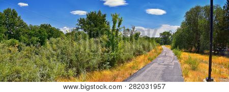 Views Of Jordan River Trail With Surrounding Trees, Russian Olive, Cottonwood And Silt Filled Muddy 
