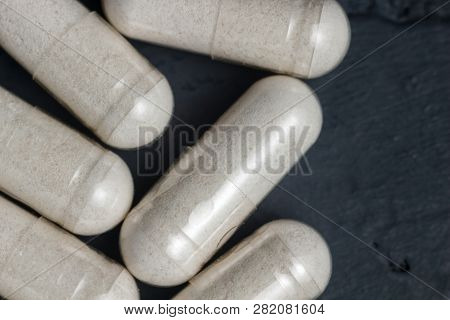 White Medical Capsules Of Glucosamine Chondroitin, Healthy Supplement Pills On A Dark Background, Ma