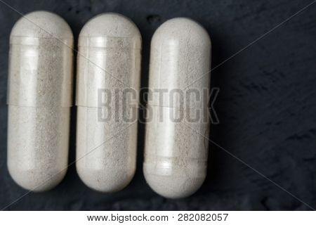 White Medical Capsules Of Glucosamine Chondroitin, Healthy Supplement Pills On A Dark Background, Ma