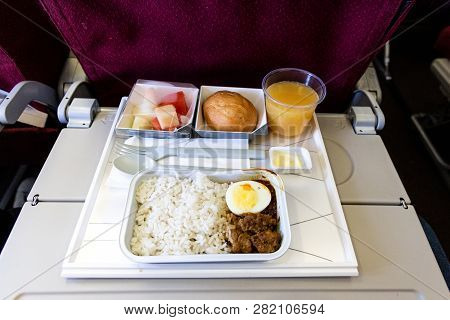Basic Inflight Meal Consisting Rice, Egg, Beef Curry, Bread, Juice.