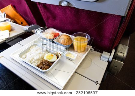 Basic Inflight Meal Consisting Rice, Egg, Beef Curry, Bread, Juice.