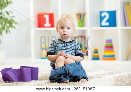 Funny Child Boy Sitting On Chamber Pot With Toilet Paper Rolls