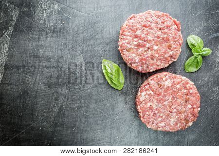 Fresh Raw Prime Black Angus Beef Burger Patties On Black Background. Top View.
