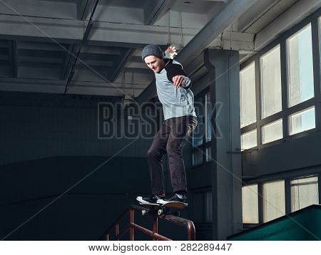 Skateboarder Performing A Trick On Mini Ramp At Skate Park Indoor.