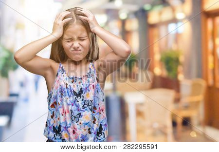 Young beautiful girl wearing colorful dress over isolated background suffering from headache desperate and stressed because pain and migraine. Hands on head.
