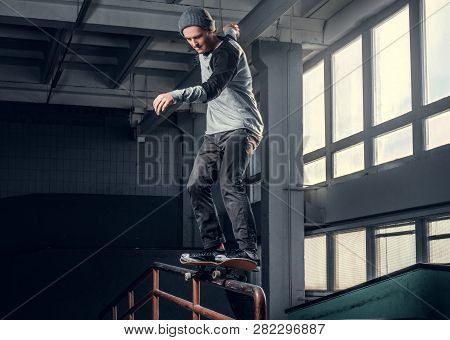 Skateboarder Performing A Trick On Mini Ramp At Skate Park Indoor.