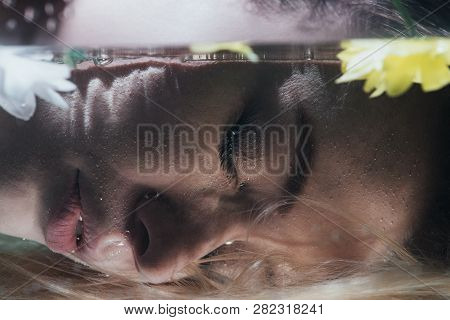 Close Up Of Young Girl Posing Underwater With Flowers