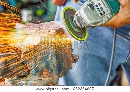 Close Up Hand And Electric Wheel Grinding On Steel Structure In Factory,sparks From The Grinding Whe