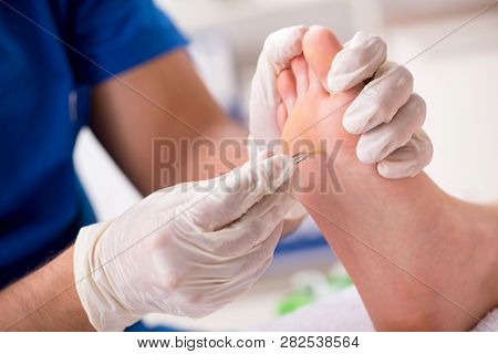 Podiatrist treating feet during procedure