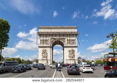 Paris, France - May 13, 2017: Famous Arc De Triomphe Against A Blue Sky With Cars In Front Of It. Th