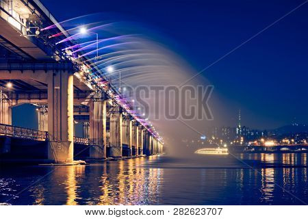 SEOUL, SOUTH KOREA - APRIL 7, 2017: Banpo Bridge Rainbow Fountain tourist landmark on Han river illuminated at night, Seoul, South Korea