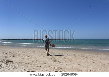 Handsome Mature Man Playing Tennis On The Beach