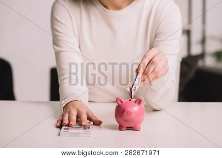 Mid Section Of Woman Putting Russian Rubles Into Piggy Bank, Savings Concept