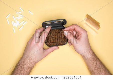 Cropped View Of Man Holding Tobacco Box Isolated On Yellow
