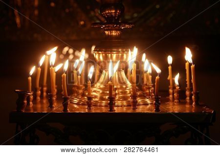 Christianity Church Interior. Set Of Lighting Candles On Dark Background