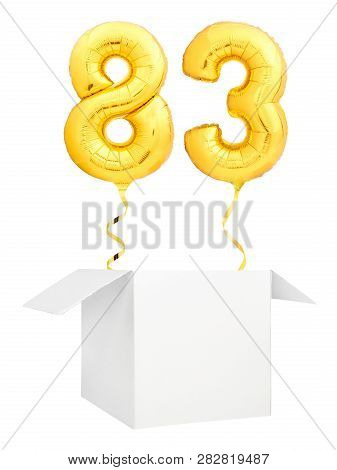 Golden Number Eighty Three Inflatable Balloon With Golden Ribbon Flying Out Of Blank White Box Isola