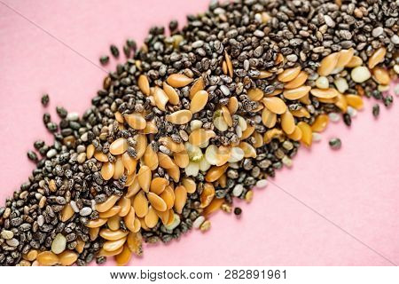 Healthy superfood:  flax seeds, chia seeds and hemp shelled seed on pink background