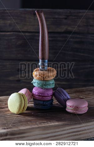 A Famous Model Of A French Knife Sticks Out Of Cookies On A Dark Wooden Background. Multi-colored Ma