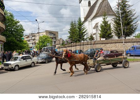 Hust, Ukraine - April 26, 2016: Men Are Not Riding A Horse-drawn Cart On A City Street.