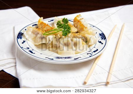 Chinese Dumplings On A Plate. Asian Fried Dumplings And Chopsticks On A Table