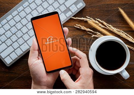 Chiang Mai / Thailand - Jan 20 2019 : Hands Hoding Mobile With Alibaba Screen, Coffee And Keyboard O