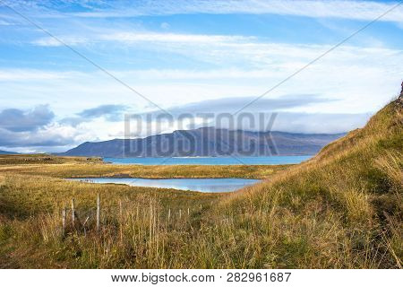 Grassy Mountains And Lake On A Clear Day In Iceland