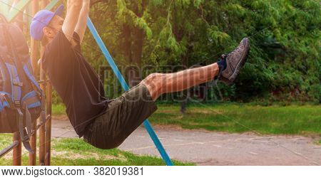 Athlete Doing Pull-up On Horizontal Bar. Male Sportsman Doing Fitness Exercises On Playground Outdoo